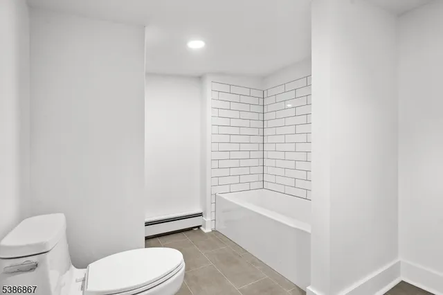 an empty room with wooden floor and white walls