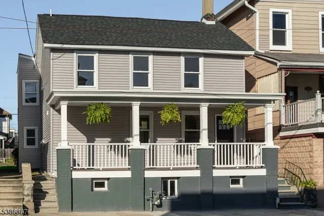 a view of a house with a small yard and deck