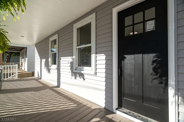a view of a brick house with large windows and wooden fence