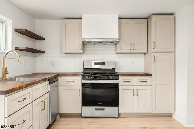 a kitchen with granite countertop a sink cabinets and stainless steel appliances