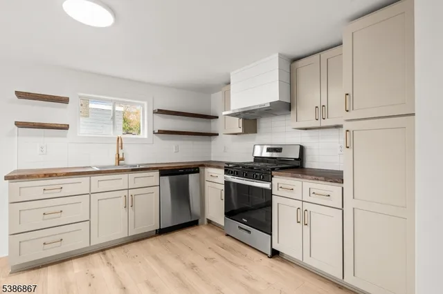 a kitchen with granite countertop white cabinets and refrigerator