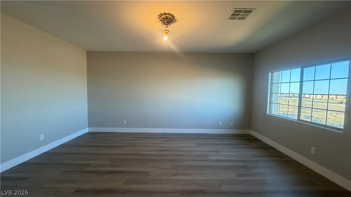 9453 Alma Ridge Avenue Las Vegas, NV 89178 - Photo 15 of 25 A spacious room offers ample natural light and durable wood-look flooring.