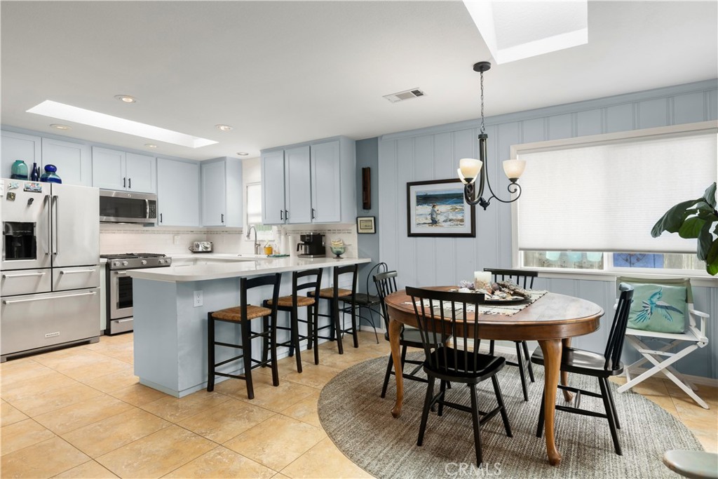 50 5th Street Cayucos, CA 93430 - Photo 20 of 47 a kitchen with stainless steel appliances kitchen island granite countertop a table chairs and a refrigerator