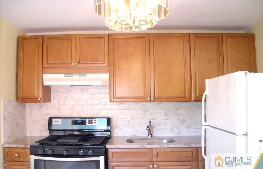 31 Markham Road Edison, NJ 08817 - Photo 7 of 13 a kitchen with granite countertop a stove a sink dishwasher and a refrigerator