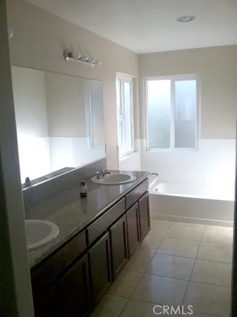 a bathroom with a granite countertop sink and a bathtub