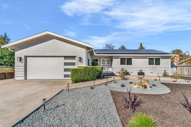 a view of a house with backyard and sitting area