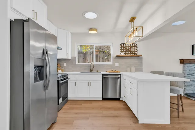 a kitchen with granite countertop a sink stainless steel appliances and cabinets