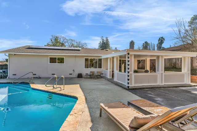 a view of a house with swimming pool and sitting area