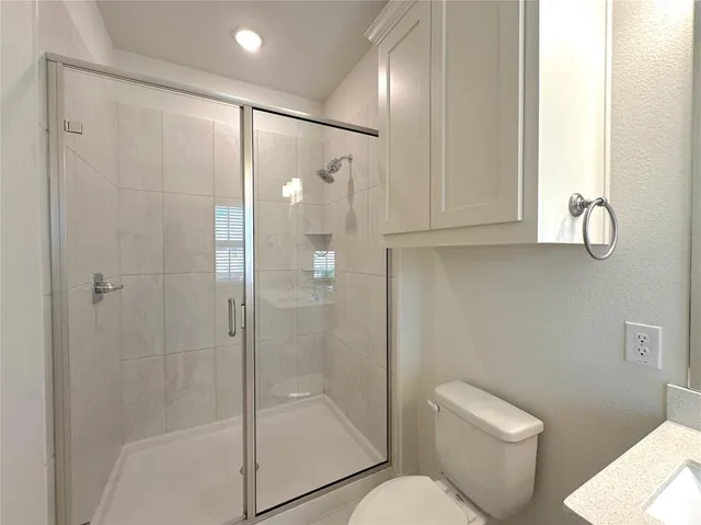 a bathroom with a shower a toilet and a sink