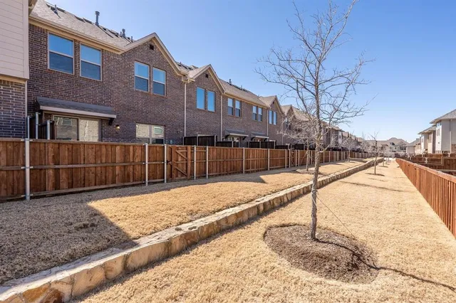 a view of a backyard with wooden fence