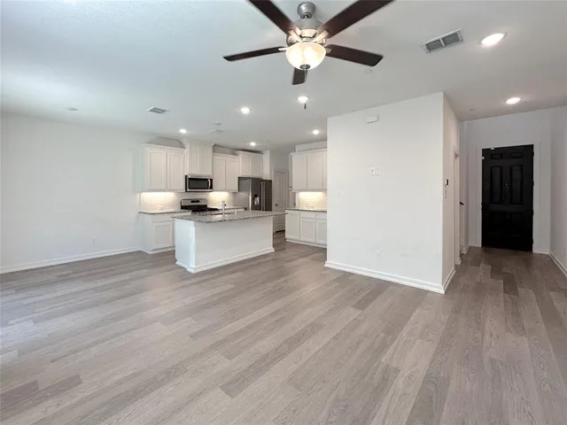 a view of kitchen with refrigerator stove microwave and cabinets