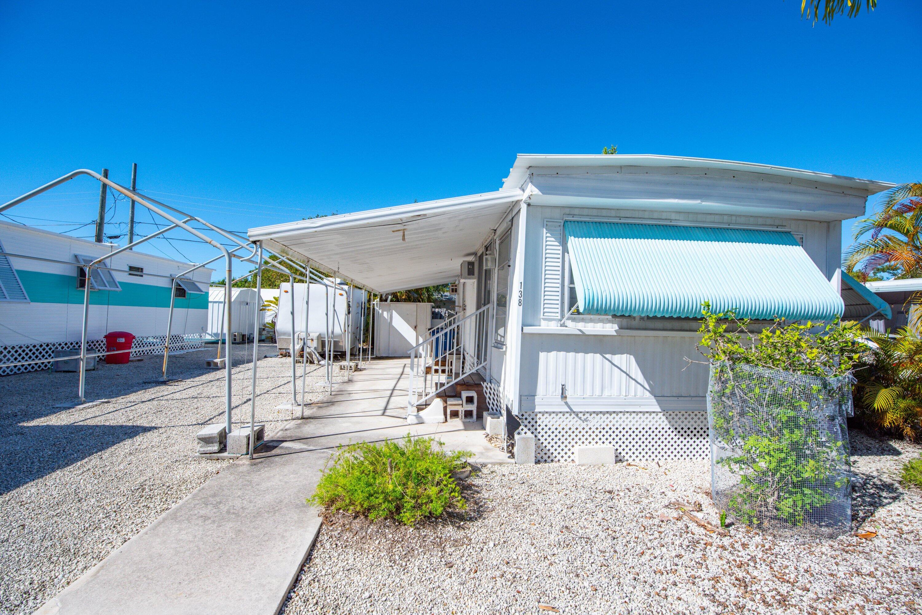 138 Sands Road Big Pine Key, FL 33043 - Photo 1 of 18 a view of a patio with table and chairs potted plants