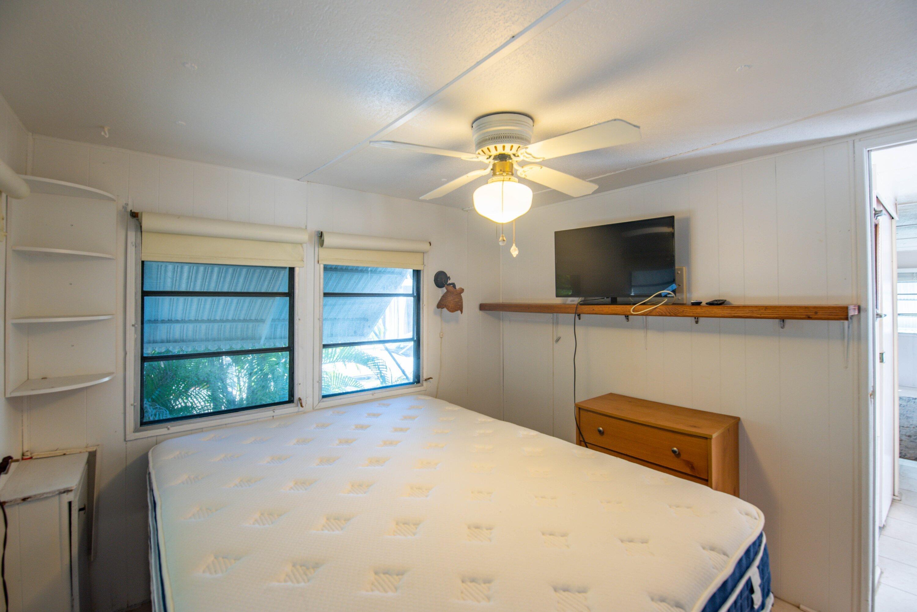 138 Sands Road Big Pine Key, FL 33043 - Photo 9 of 18 a bedroom with a bed and a flat screen tv