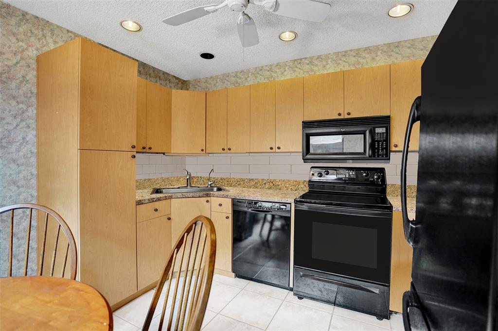 9132 Southwest 20th Street, Unit B Boca Raton, FL 33428 - Photo 15 of 81 a kitchen with stainless steel appliances granite countertop a stove a sink and a refrigerator