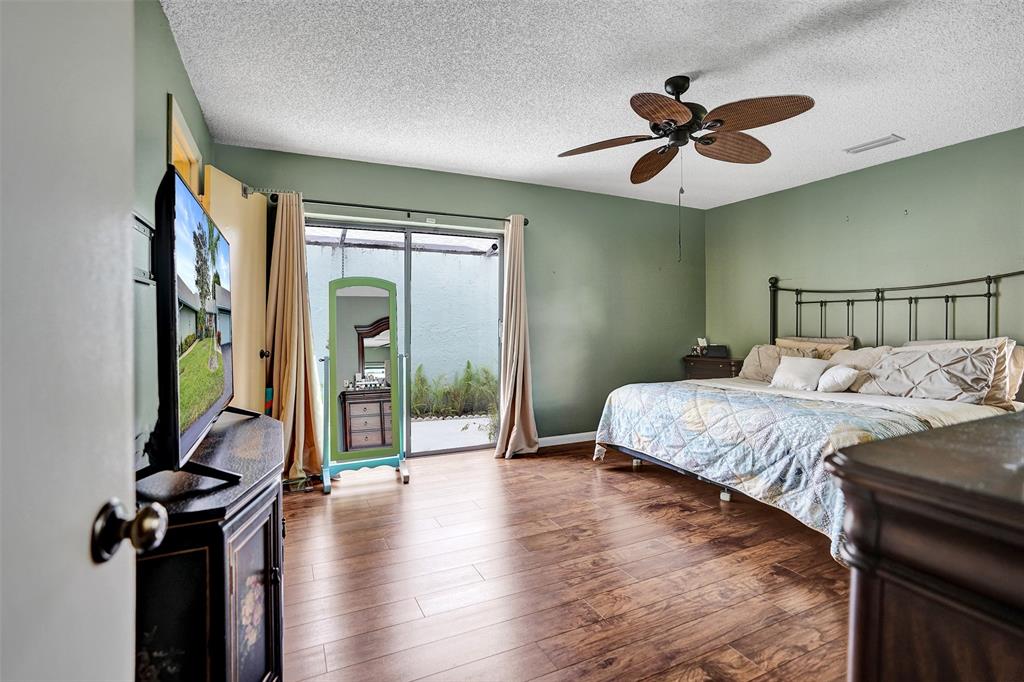 9132 Southwest 20th Street, Unit B Boca Raton, FL 33428 - Photo 22 of 81 a bedroom with a balcony a bed and a chandelier