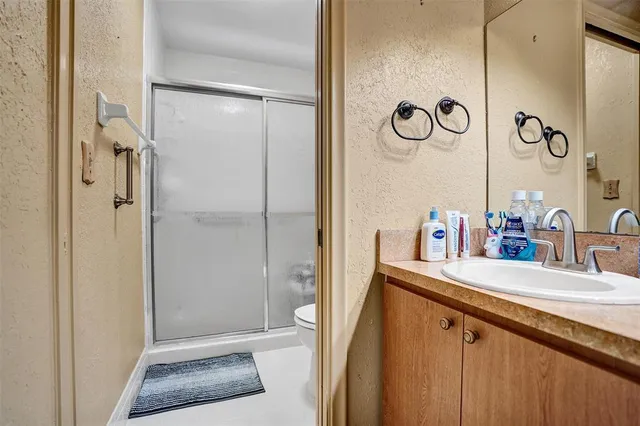 a bathroom with a granite countertop sink toilet and shower