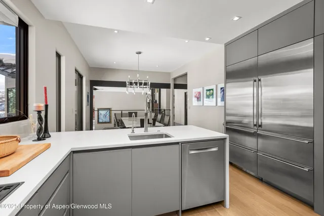 a kitchen with kitchen island a counter top space a sink stainless steel appliances and cabinets