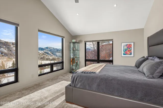 a bedroom with a bed and a large window