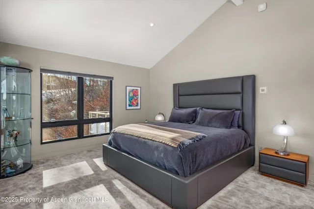 a bedroom with a bed and a large window