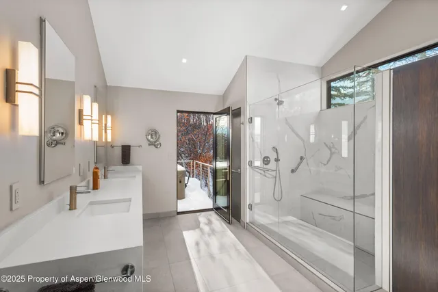 a spacious bathroom with a double vanity sink a large mirror a shower and bathtub