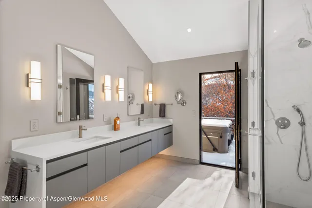 a bathroom with a double vanity sink mirror and shower