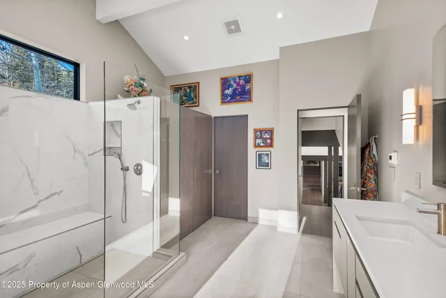a en suite bathroom with a shower sink and mirror