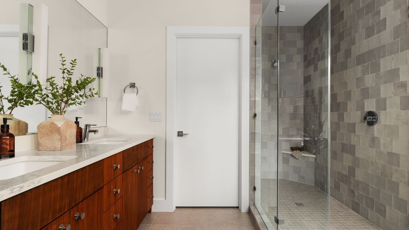 3813 Tilley Street Austin, TX 78723 - Photo 15 of 26 a bathroom with a granite countertop sink a mirror and shower