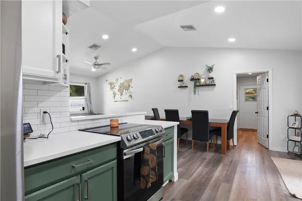 a kitchen that has a sink a stove and chairs