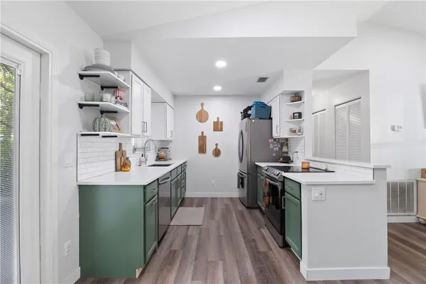a kitchen with kitchen island a sink stove and cabinets