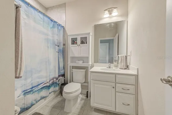 a bed sitting in a bedroom next to a window with pc on the table