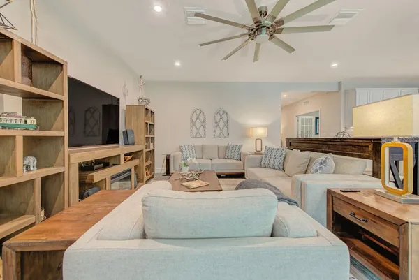 a large living room with a couch and a view of kitchen