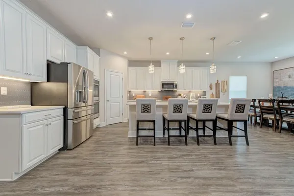 a kitchen with kitchen island a sink and a stove with wooden floor