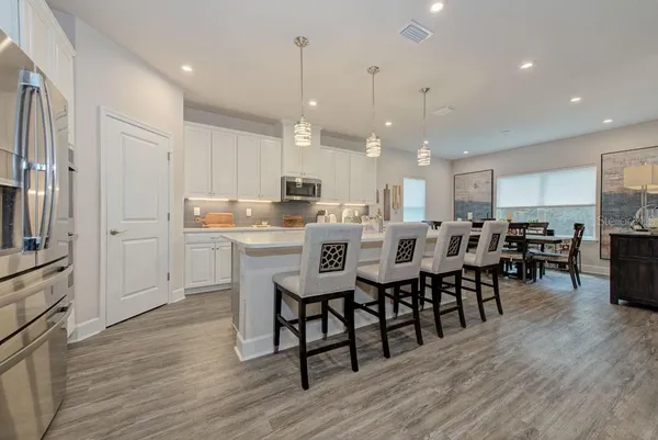 a large kitchen with a table and chairs