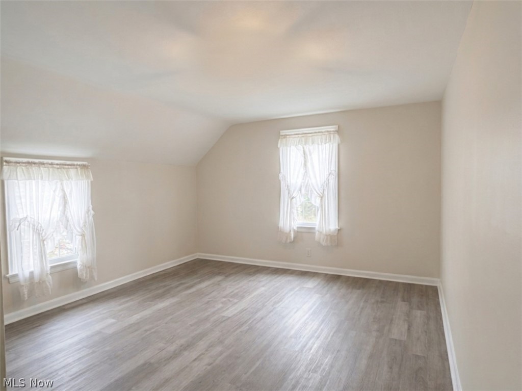 2800 Hillside Road Seven Hills, OH 44131 - Photo 12 of 18 Spacious room featuring sloped ceilings, two windows with white trim, Vinyl Flooring.