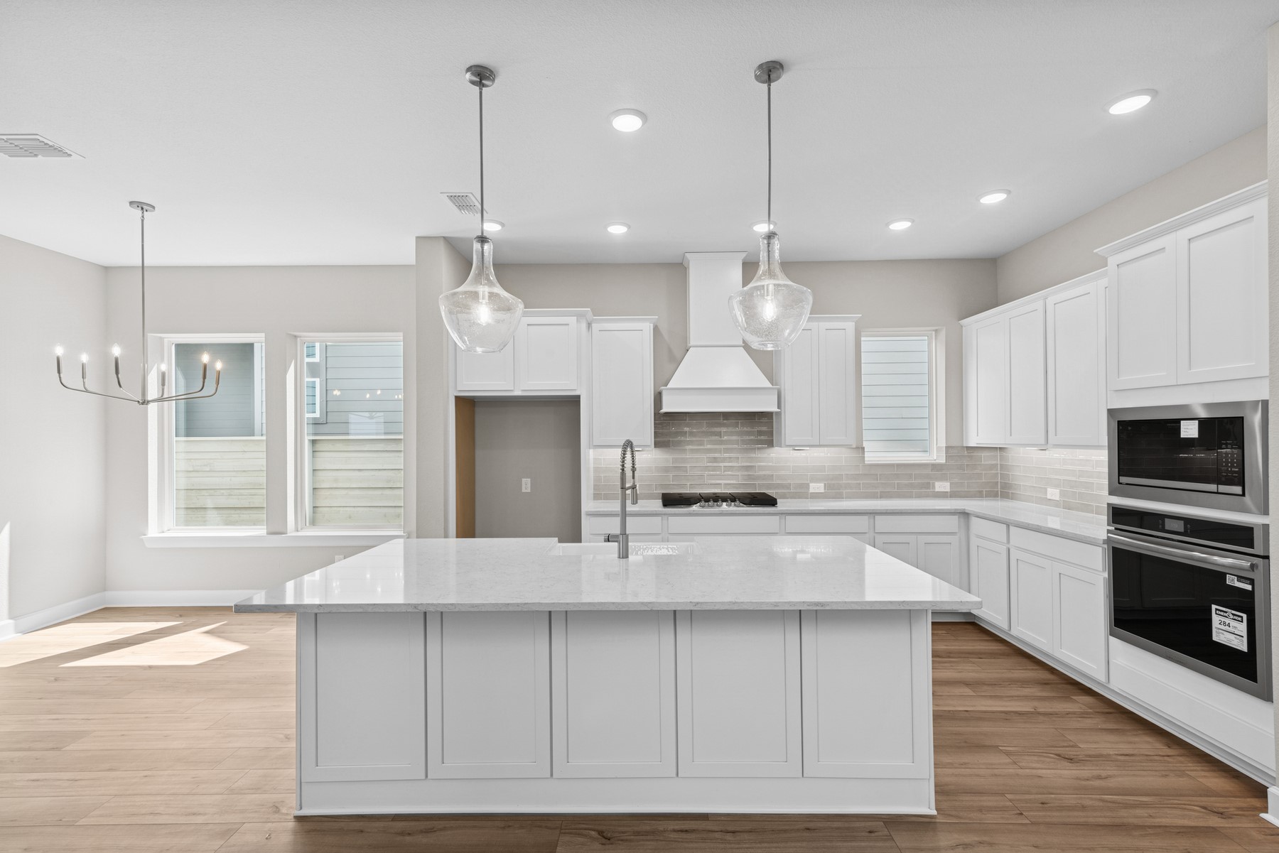 5515 Orangery Lane Manvel, TX 77578 - Photo 18 of 48 a large kitchen with kitchen island granite countertop a stove a sink a center island a refrigerator and a wooden floor