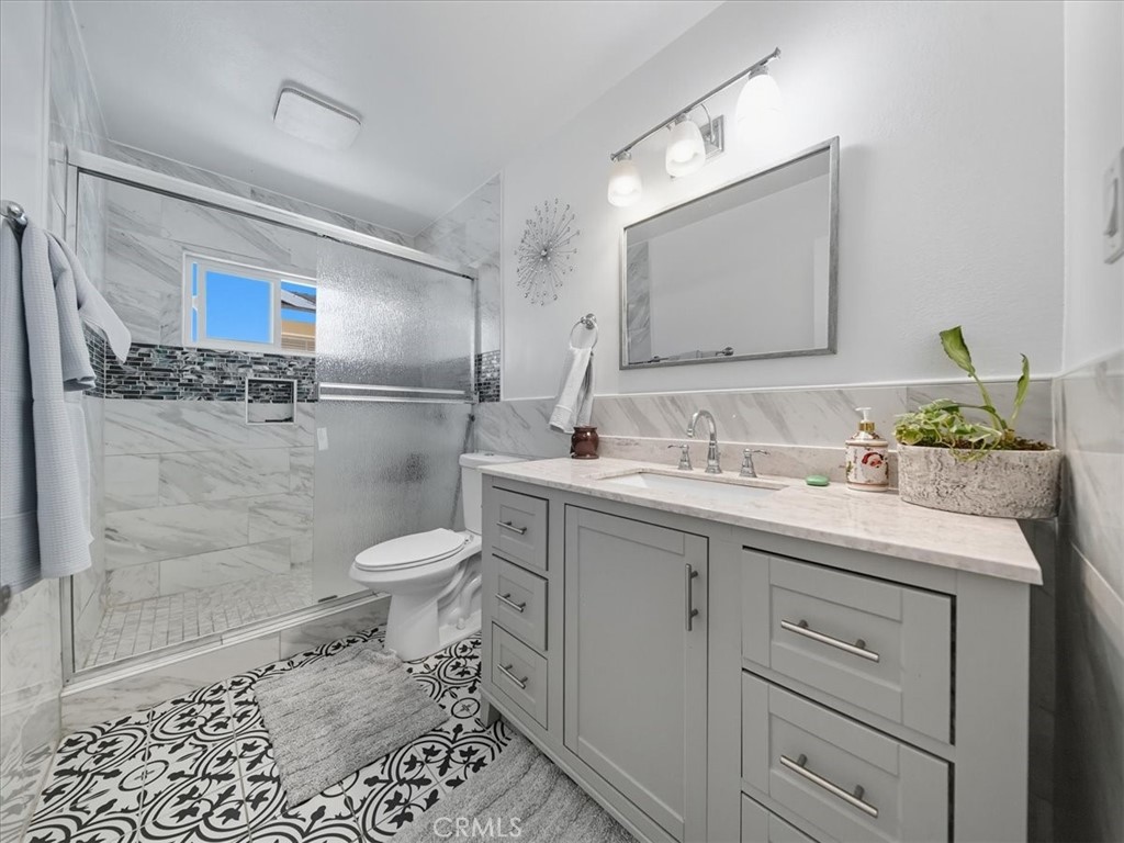 1407 Colonial Avenue Anaheim, CA 92802 - Photo 18 of 33 a bathroom with a granite countertop toilet sink and a mirror