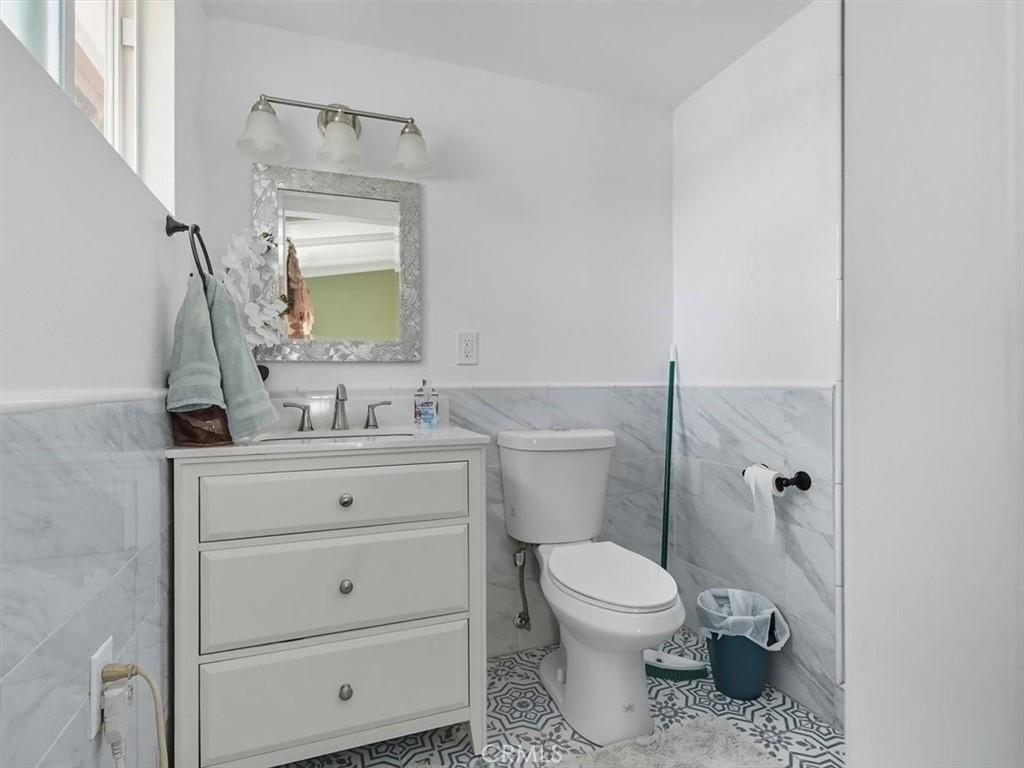 1407 Colonial Avenue Anaheim, CA 92802 - Photo 21 of 33 a bathroom with a granite countertop toilet sink and mirror