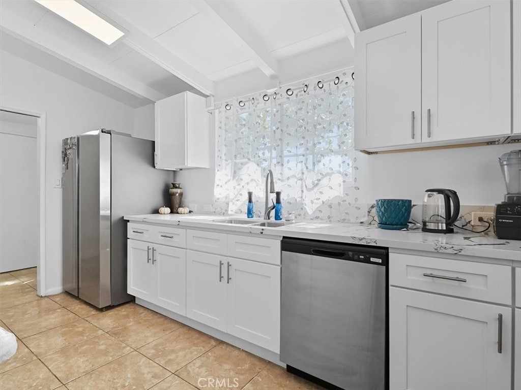 1407 Colonial Avenue Anaheim, CA 92802 - Photo 10 of 33 a kitchen with stainless steel appliances granite countertop a refrigerator sink and white cabinets
