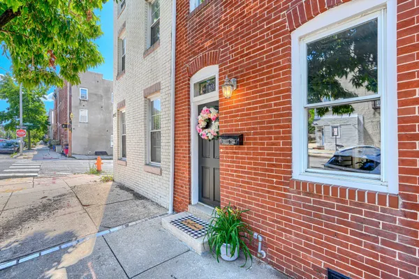 a view of a brick house with a potted plant and floor to ceiling windows