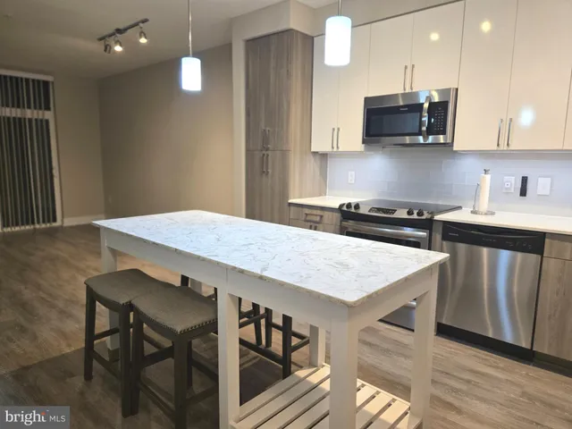 a kitchen with kitchen island a stove a table and chairs in it