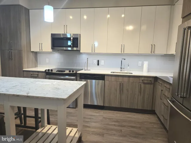 a kitchen with stainless steel appliances granite countertop a sink a stove a refrigerator and a microwave