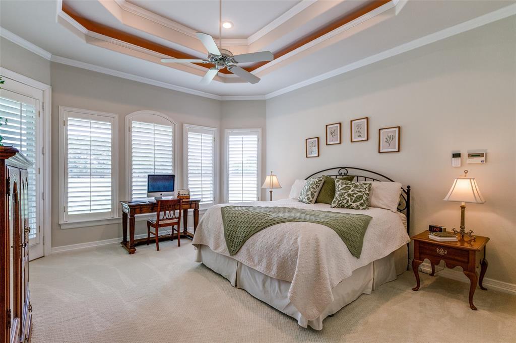 12198 Bell Road Pilot Point, TX 76258 - Photo 16 of 40 The luxurious primary suite offers plenty of windows and patio access, while featuring ornamental molding and a raised ceiling.