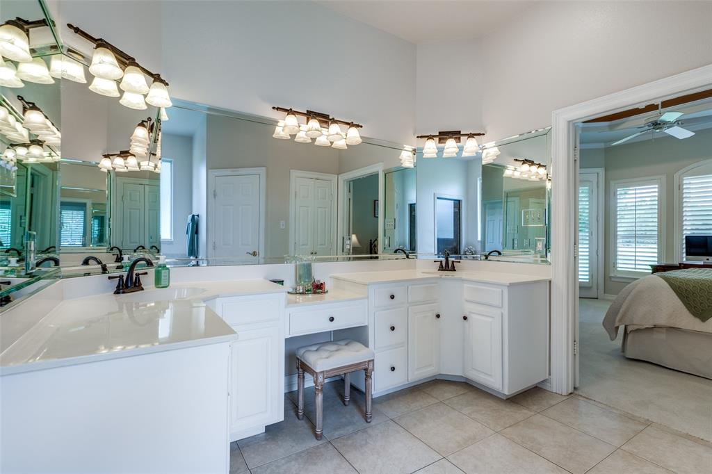12198 Bell Road Pilot Point, TX 76258 - Photo 18 of 40 The primary ensuite bathroom offers dual vanities, a high ceiling, tile floors, & plenty of mirrors.