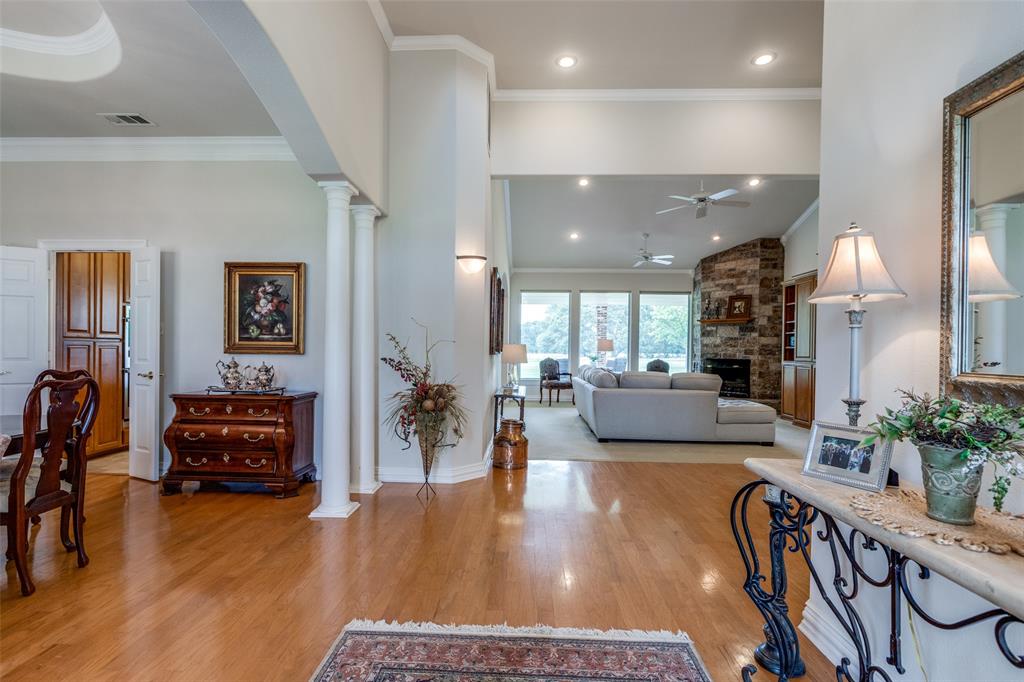 12198 Bell Road Pilot Point, TX 76258 - Photo 3 of 40 The living room boasts vaulted ceiling, wood flooring, a stone fireplace, and ornate columns.