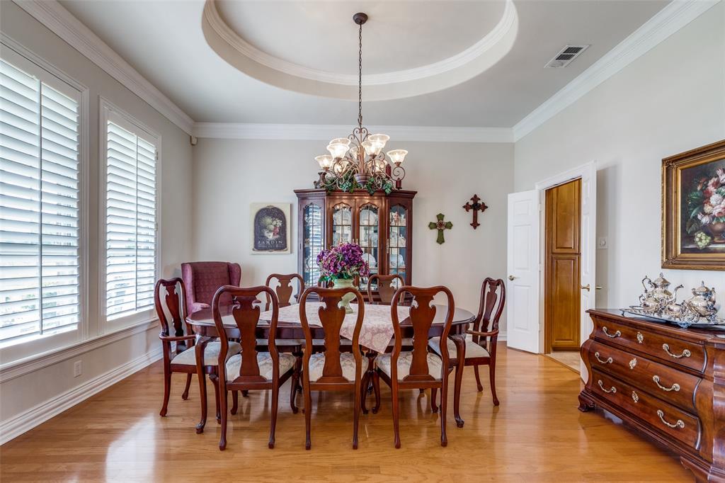 12198 Bell Road Pilot Point, TX 76258 - Photo 4 of 40 The dining room features plenty of natural light, plantation shutters, a tray ceiling, wood flooring, and an inviting chandelier.
