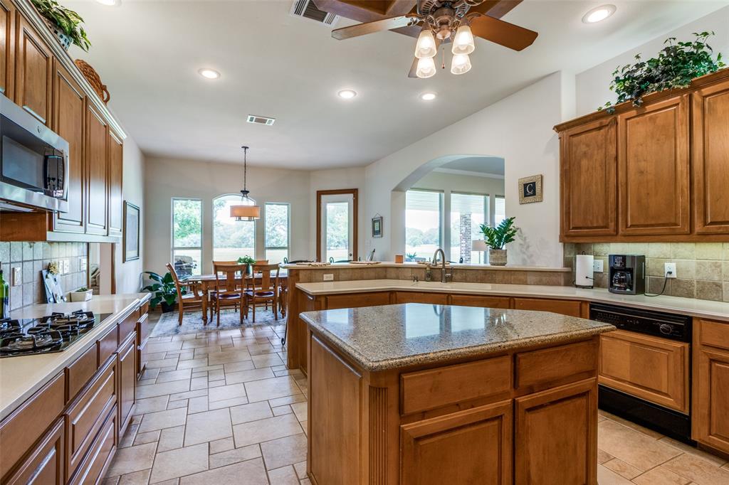12198 Bell Road Pilot Point, TX 76258 - Photo 8 of 40 Kitchen featuring appliances with stainless steel finishes, tasteful backsplash, light tile floors, and a kitchen island