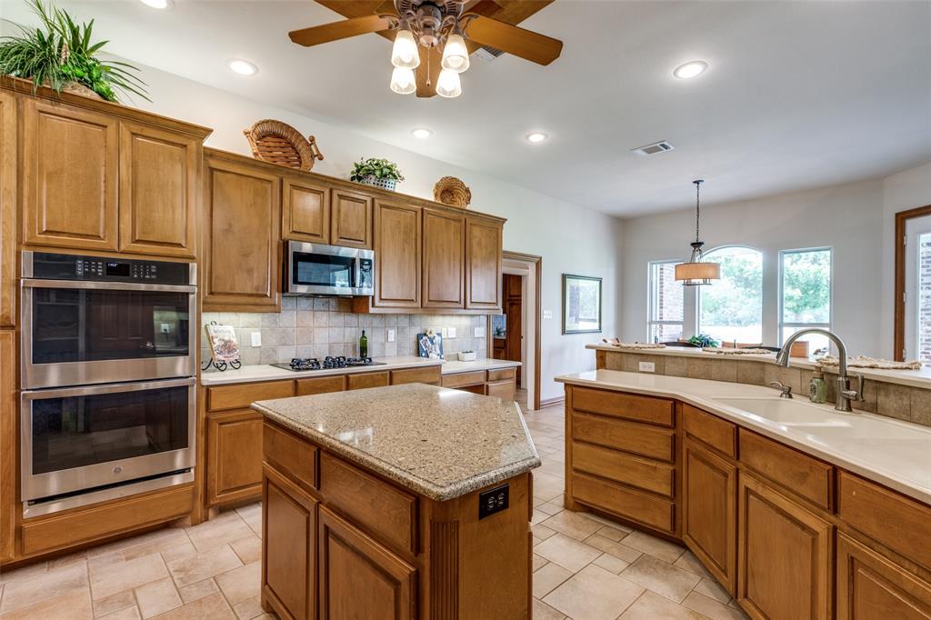 12198 Bell Road Pilot Point, TX 76258 - Photo 9 of 40 The center island offers additional counter space for food preparation and serving.
