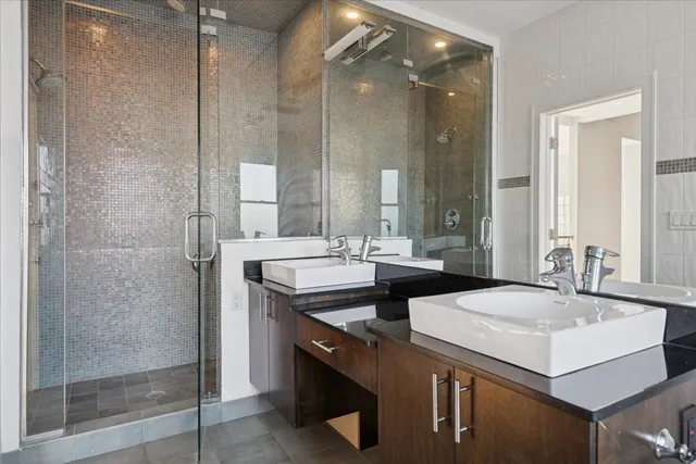 a bathroom with double sink and two mirror