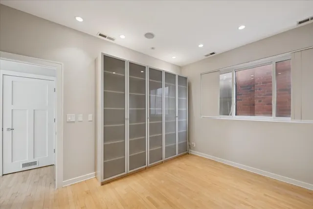 a view of an empty room with a window and a kitchen