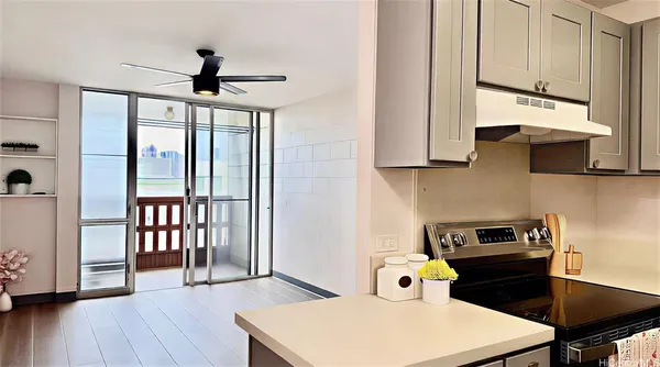 a kitchen that has a microwave a stove and a wooden floor